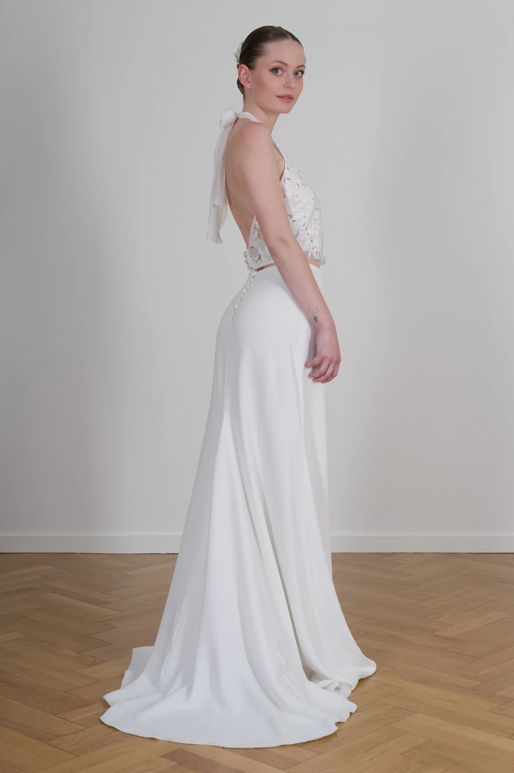 Robe de mariée dos nu avec nœud en ruban et détails en dentelle florale.