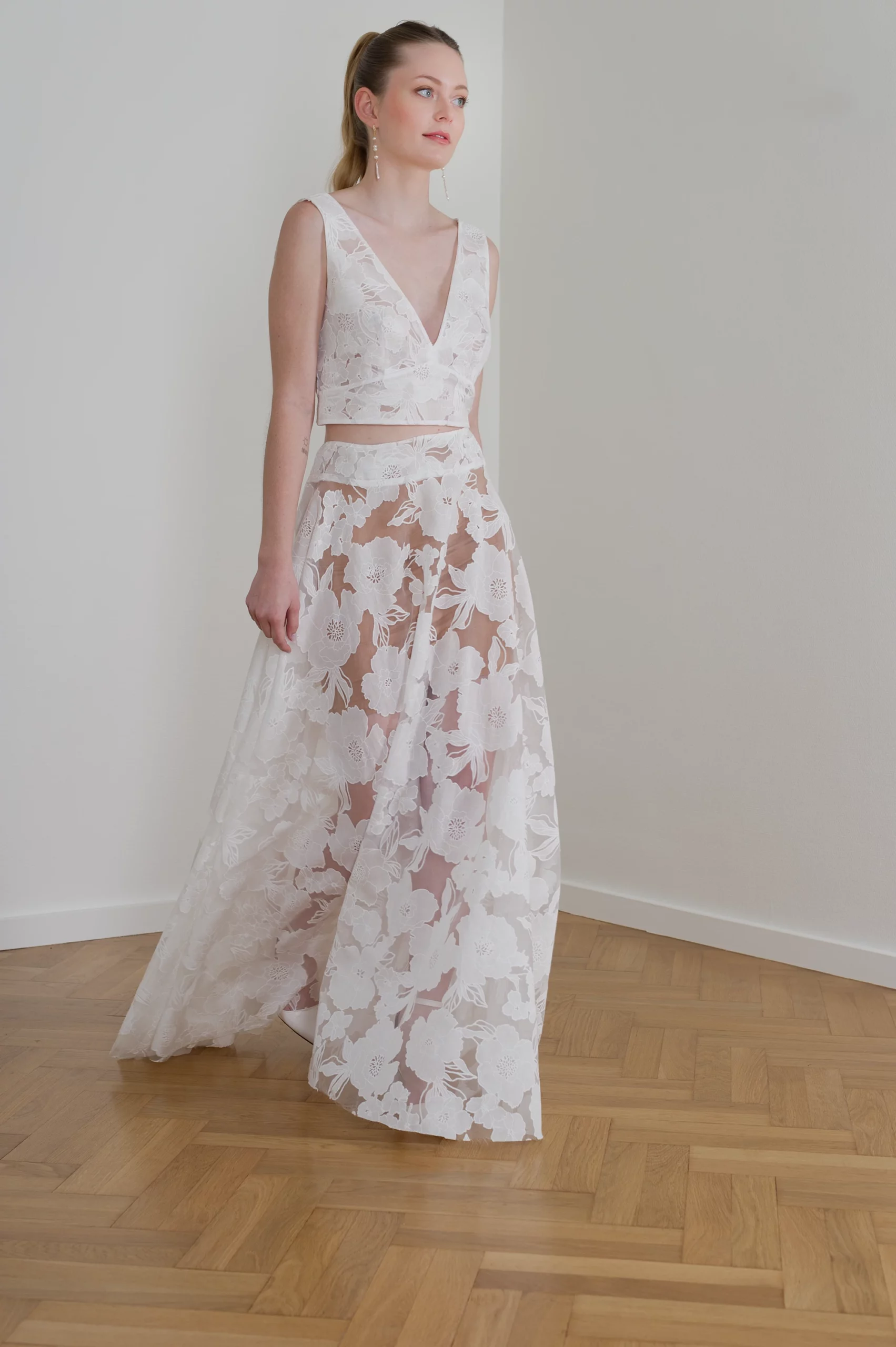 Robe de mariée deux pièces en dentelle florale avec jupe transparente.