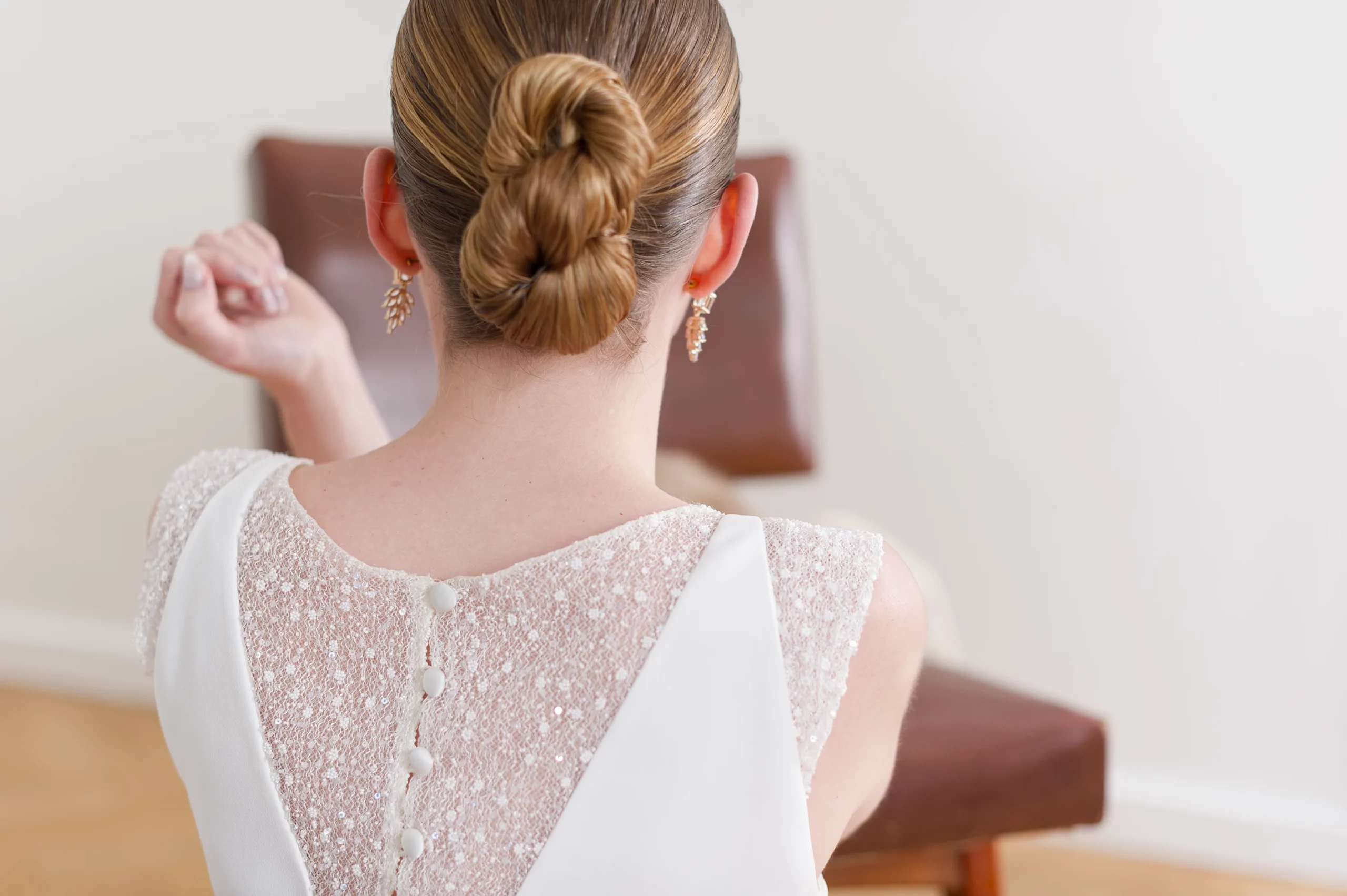 Détail du dos en dentelle scintillante avec boutons sur une robe de mariée.