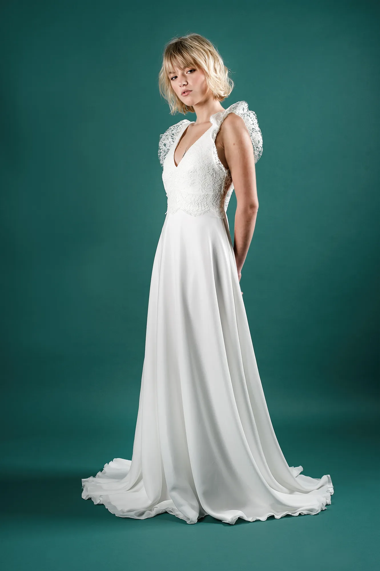 Robe de mariée 'Hannah' avec dentelle délicate et manches en dentelle florale, vue de profil, disponible à Toulouse.