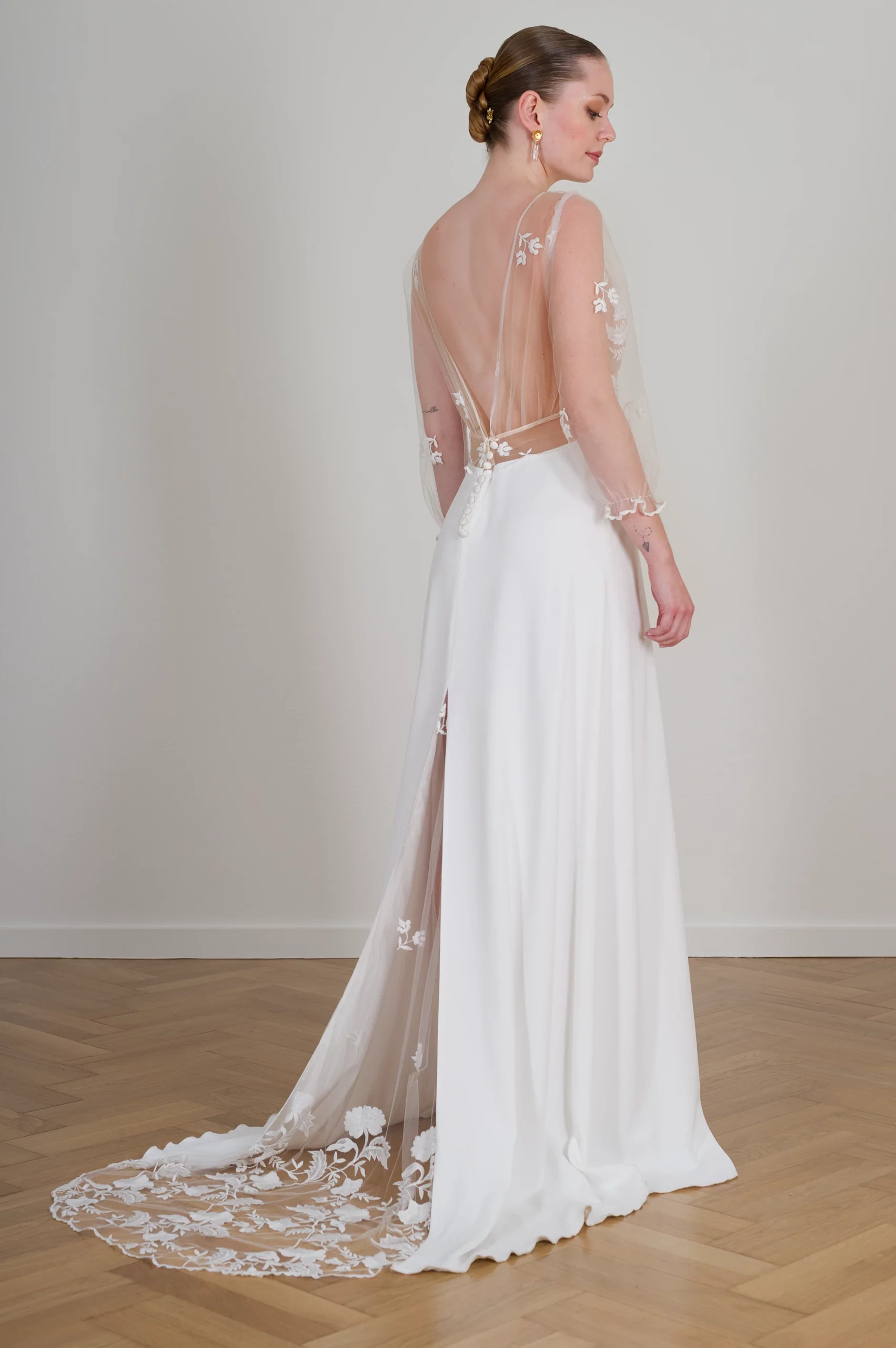 Robe de mariée Sophia vue de dos avec traîne en tulle brodé et dos plongeant transparent.