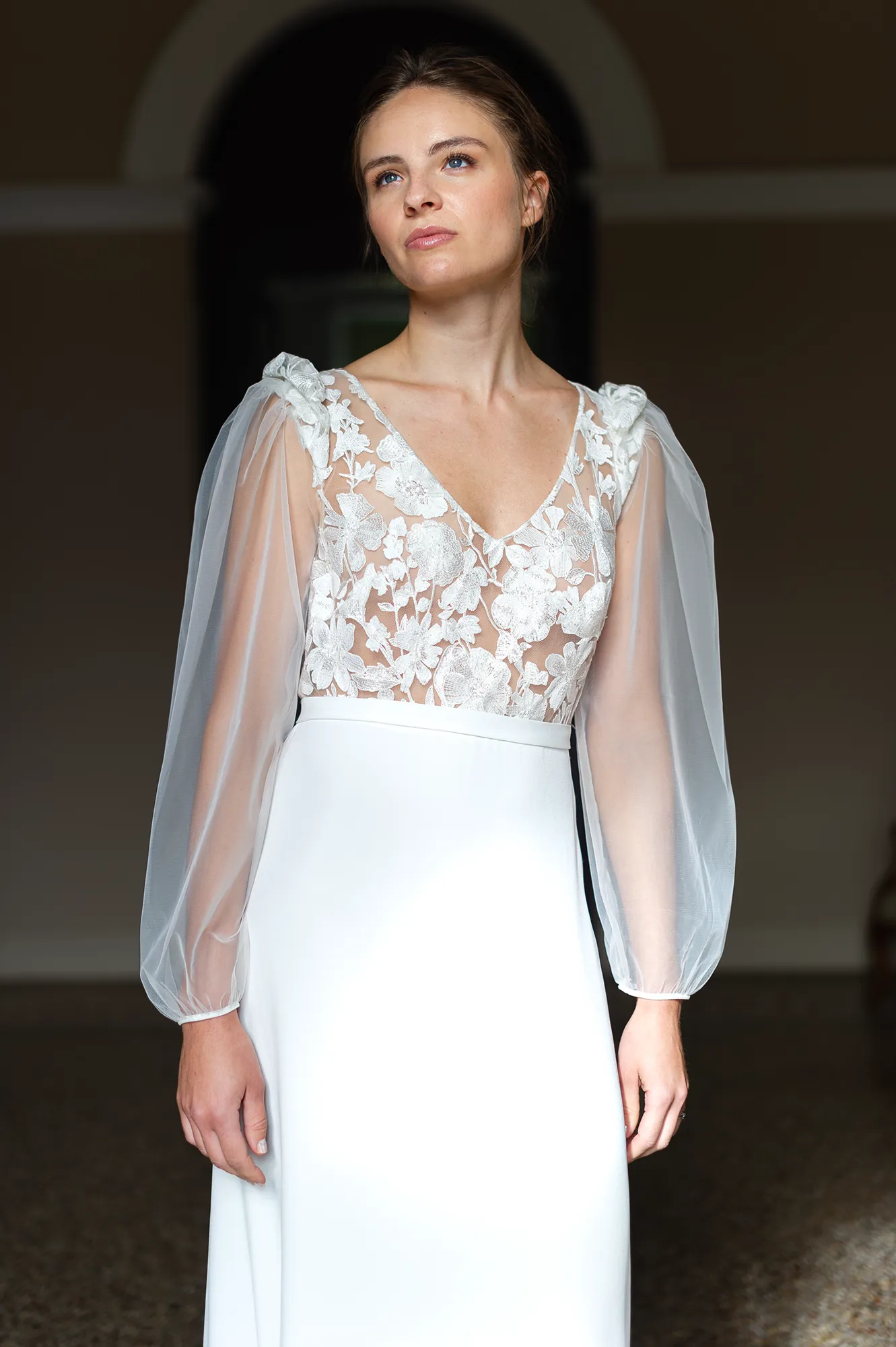 robe-mariee-alma-bustier-brode-manches-tulle-louise-dentelle Robe de mariée Alma en gros plan, buste brodé avec décolleté V et manches longues en tulle léger. Création Louise Dentelle.