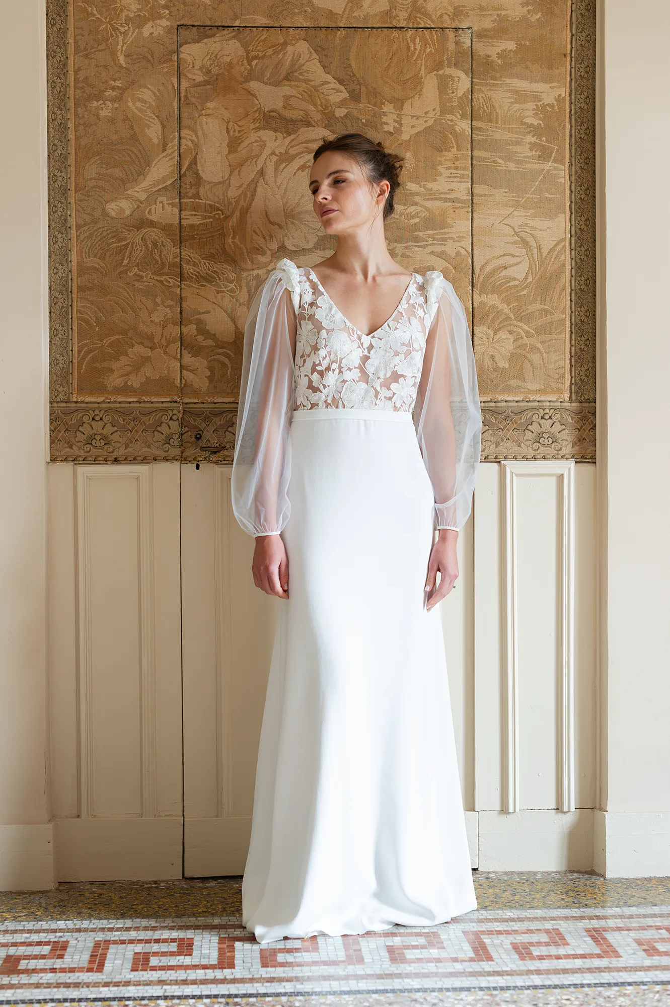 Robe de mariée Alma vue de face, top brodé floral transparent et manches en tulle, jupe en crêpe fluide. Création Louise Dentelle.