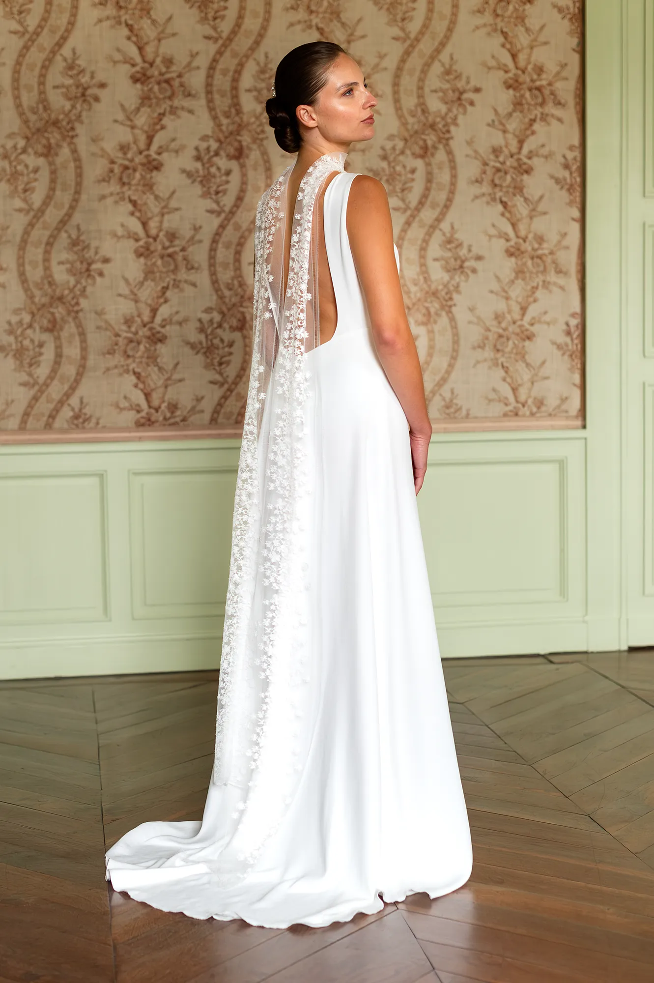Robe de mariée Cristina vue de dos, écharpe en dentelle de Calais-Caudry tombant le long du dos et coupe fluide. Création Louise Dentelle à Toulouse.