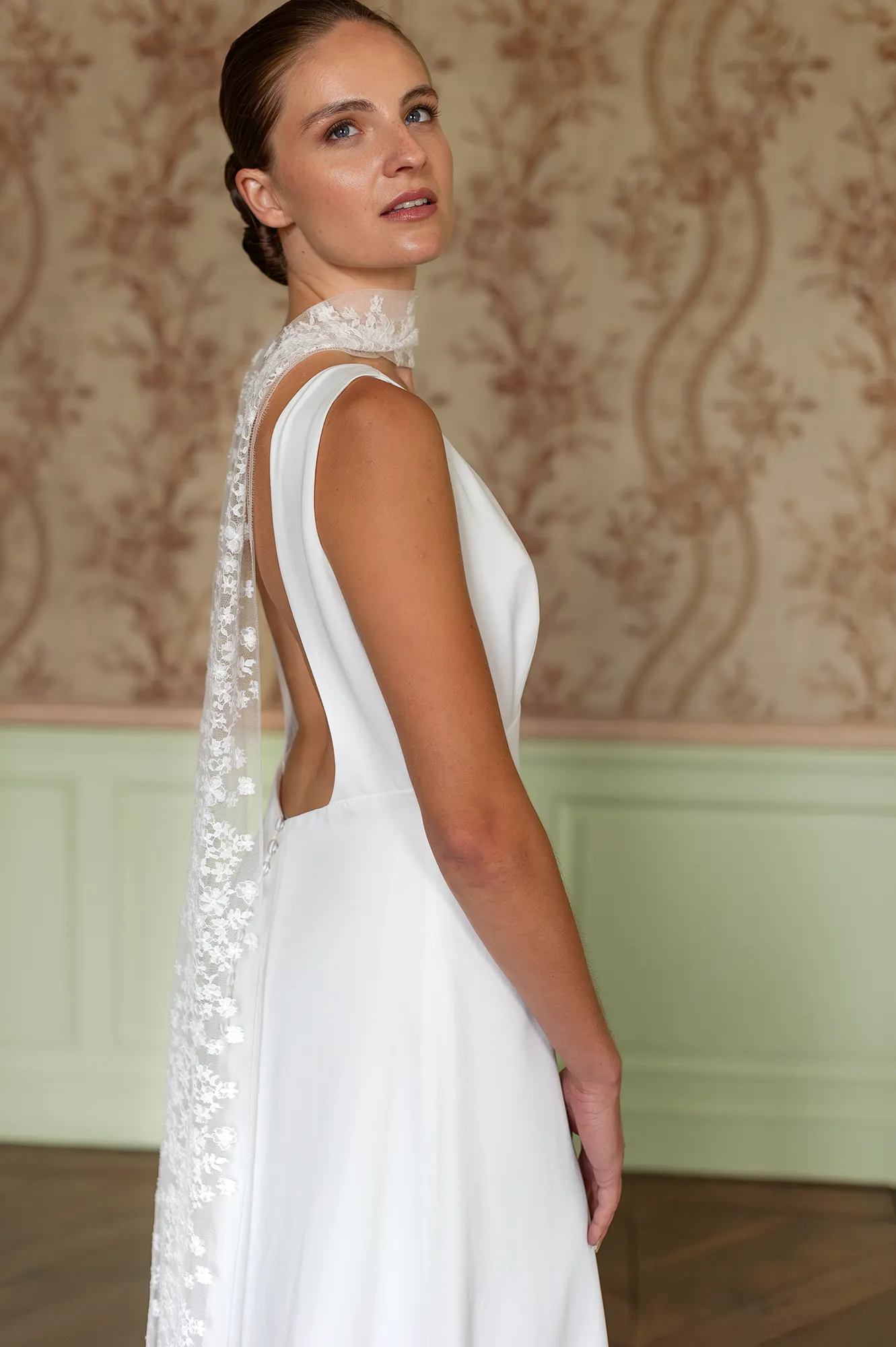 Robe de mariée Cristina en gros plan, décolleté plongeant et écharpe en dentelle de Calais-Caudry tombant sur le dos. Création Louise Dentelle à Toulouse.