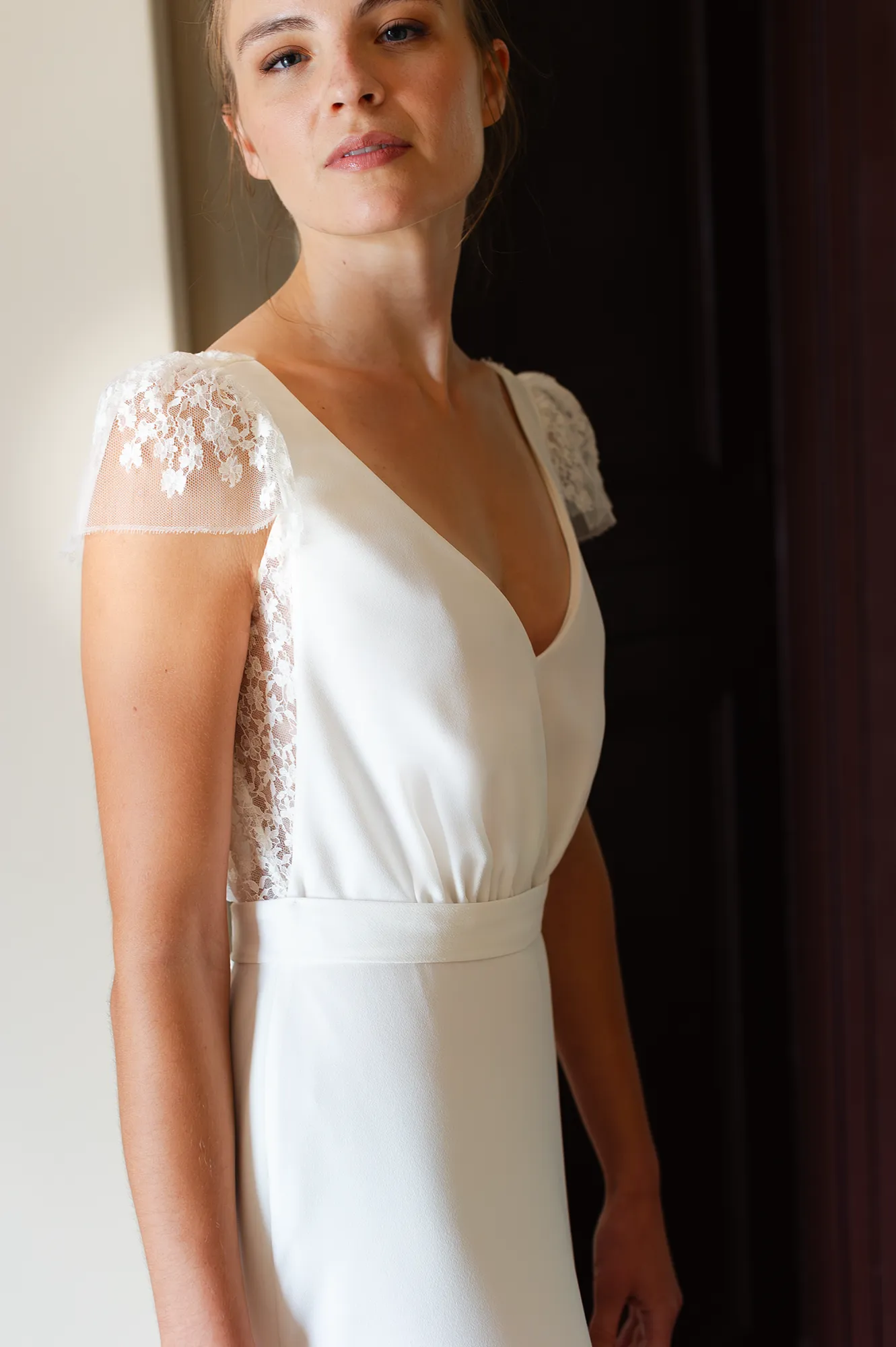 Robe de mariée Rebecca en détail, décolleté V et petites manches en dentelle de Calais-Caudry. Création Louise Dentelle.
