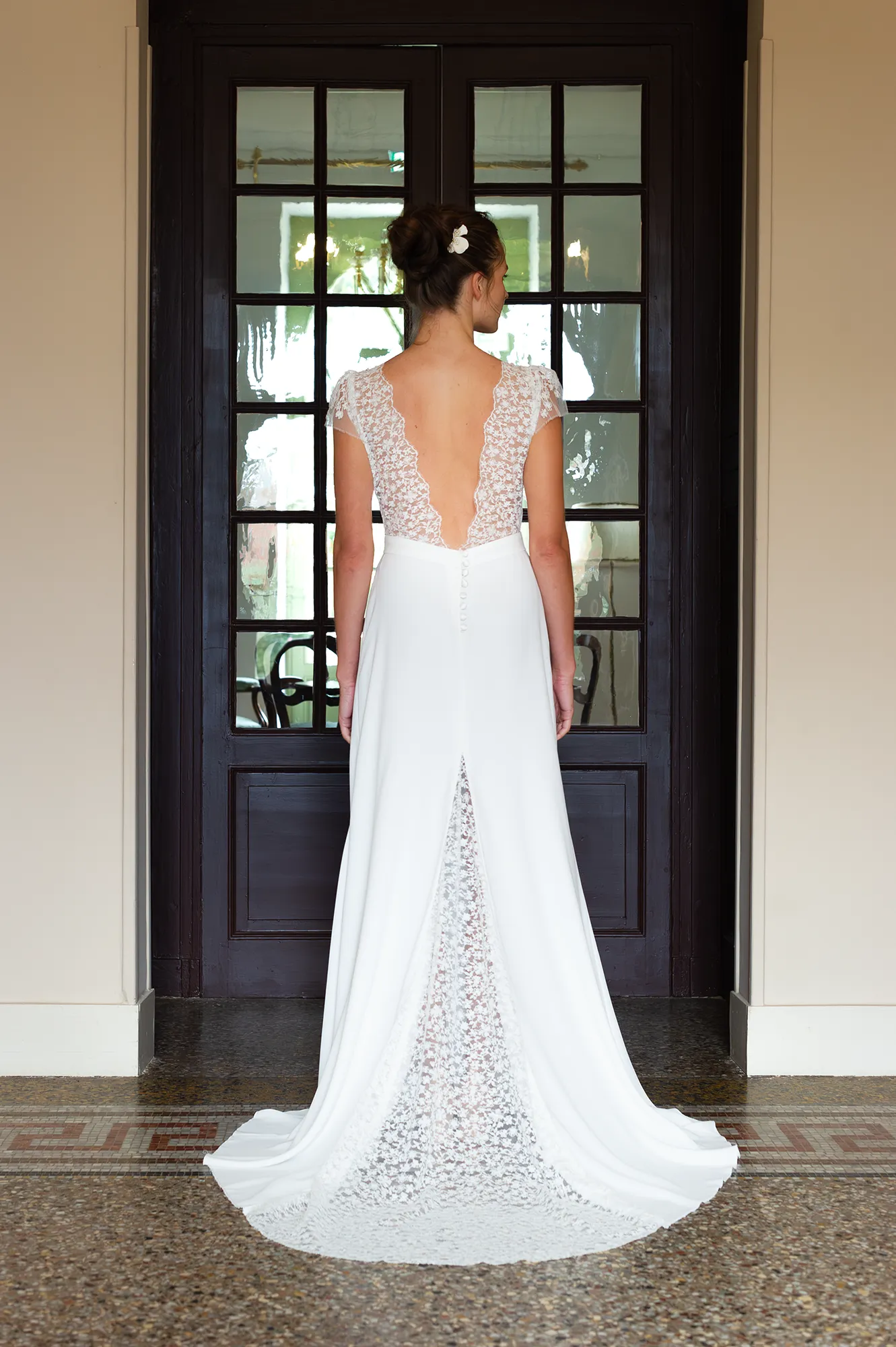 Robe de mariée Rebecca en vue de dos, décolleté plongeant en dentelle de Calais-Caudry, traîne en dentelle et fente dos. Création Louise Dentelle.