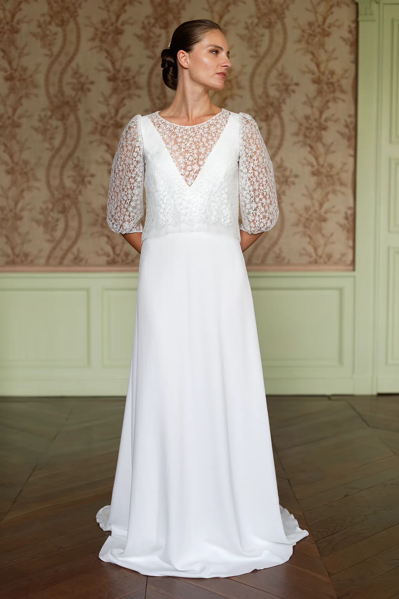 Modèle Theresa avec paletot en dentelle, manches bouffantes 3/4 et décolleté triangulaire transparent. Création Louise Dentelle à Toulouse.