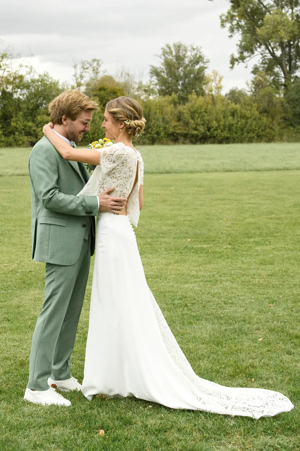 Julia portant une robe de mariée sur mesure en dentelle lors d’un moment avec le marié création Louise Dentelle.