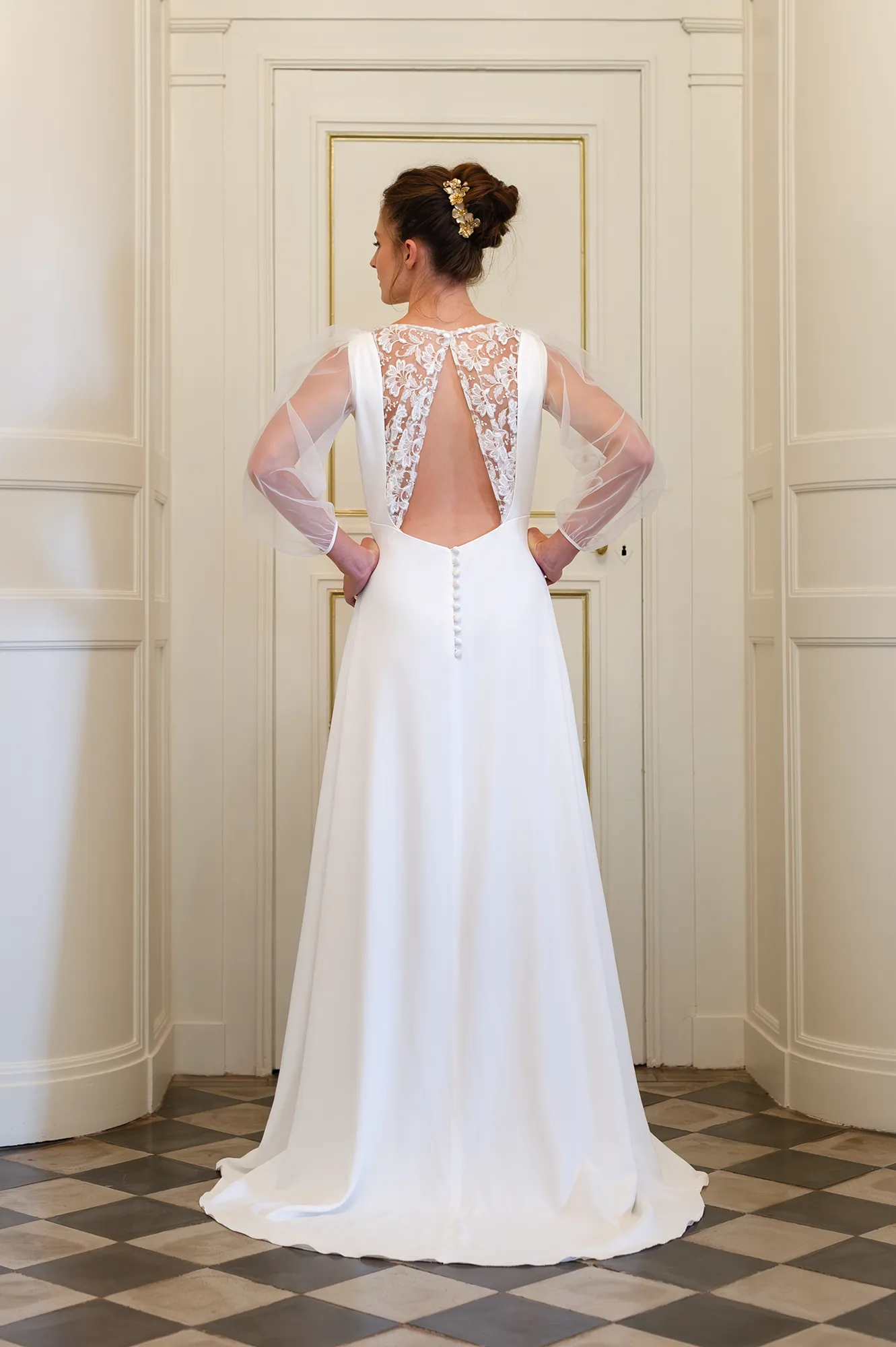 Robe de mariée Elena vue de dos, ouverture en V avec dentelle brodée, manches en tulle et boutons recouverts. Création Louise Dentelle à Toulouse.